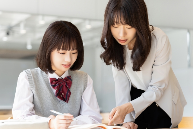 塾で勉強を教えてもらう高校生